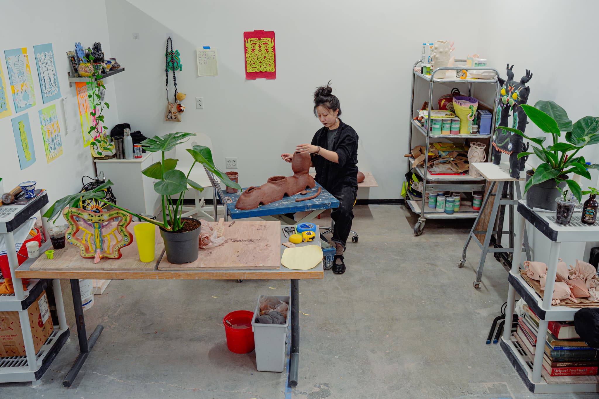 An artist works on a clay sculpture in her studio.