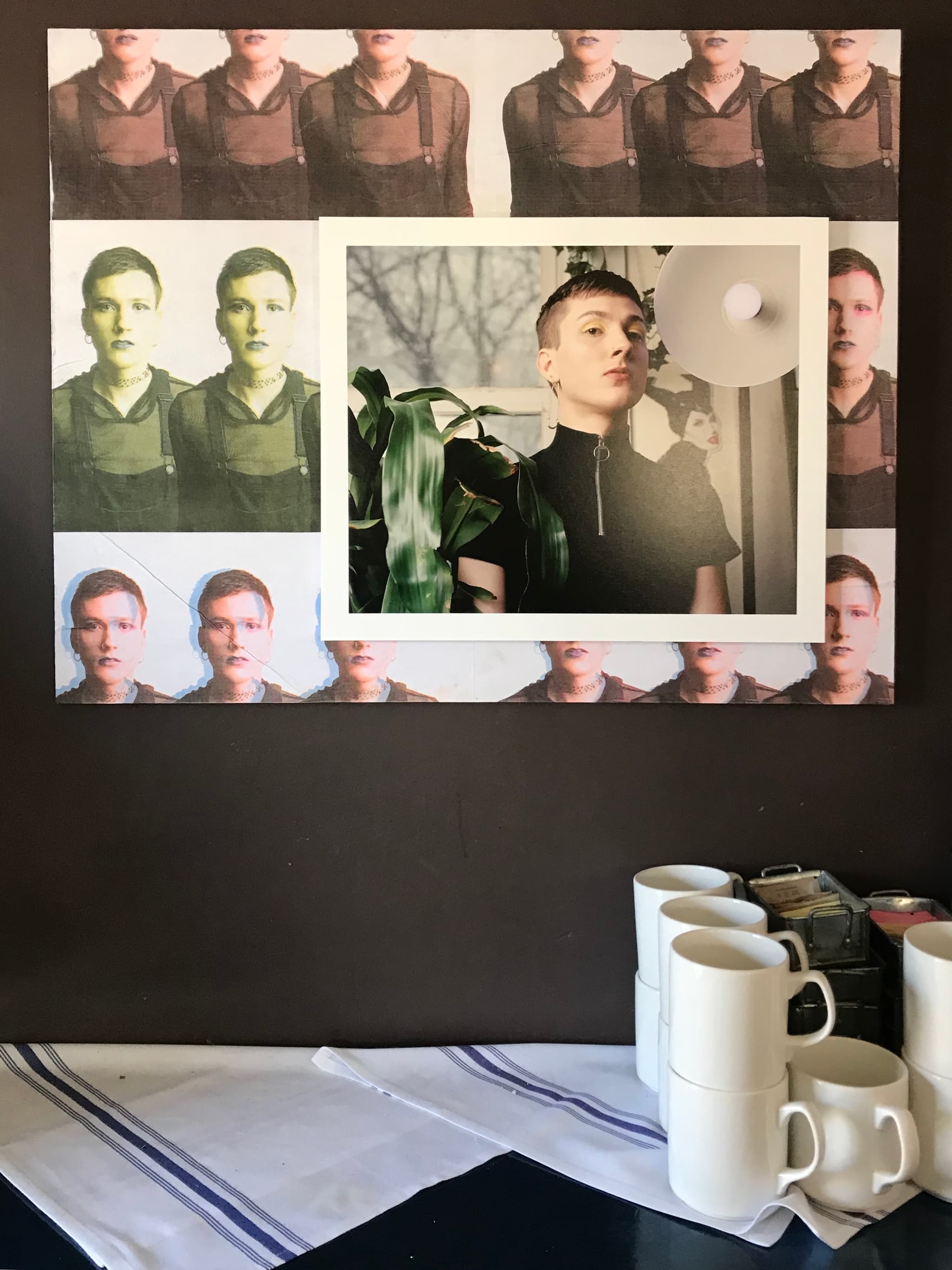 Leah Eve Corbett's photography on the wall at Tres Gatos. Nearby to the right are mugs and sweeteners.